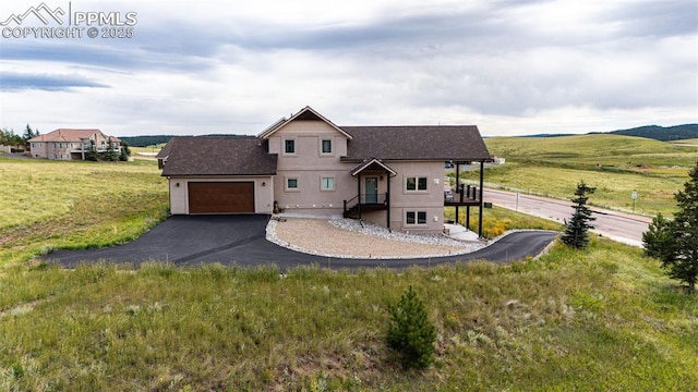 view of front of home with a rural view and a garage