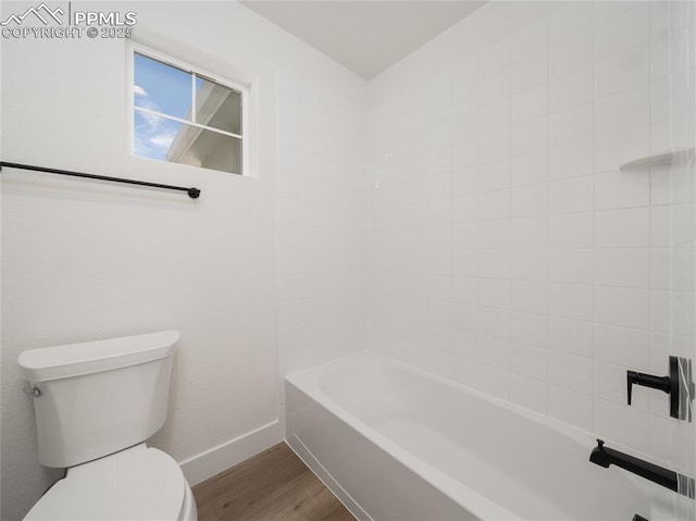 full bathroom featuring toilet, shower / washtub combination, wood finished floors, and baseboards