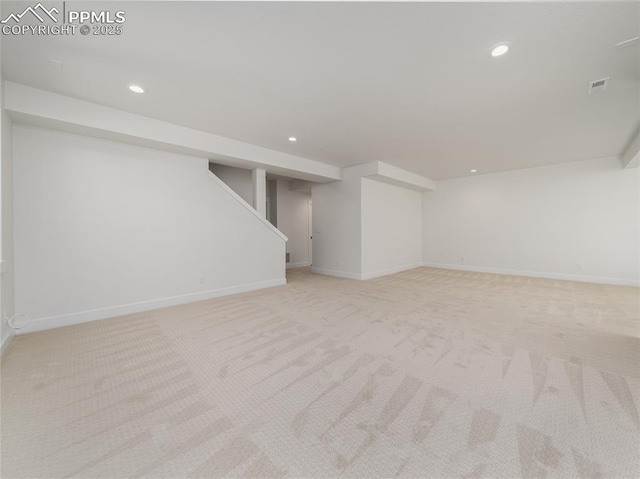 finished basement with light carpet, visible vents, and recessed lighting