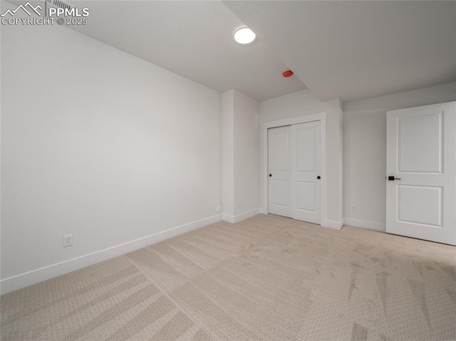 empty room with light colored carpet and baseboards