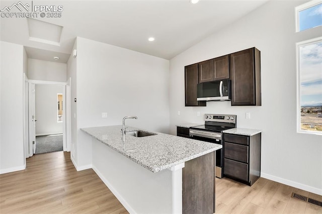 241 N Front St Unit 101, Monument, CO 80132 - kitchen featuring light wood finished floors, a sink, dark brown cabinetry, light stone counters, and appliances with stainless steel finishes