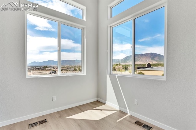 241 N Front St Unit 101, Monument, CO 80132 - spare room with a mountain view, visible vents, baseboards, and wood finished floors