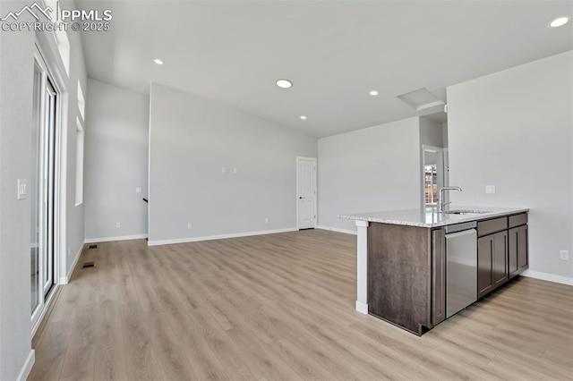 241 N Front St Unit 101, Monument, CO 80132 - kitchen featuring light wood finished floors, dishwasher, a sink, baseboards, and dark brown cabinetry
