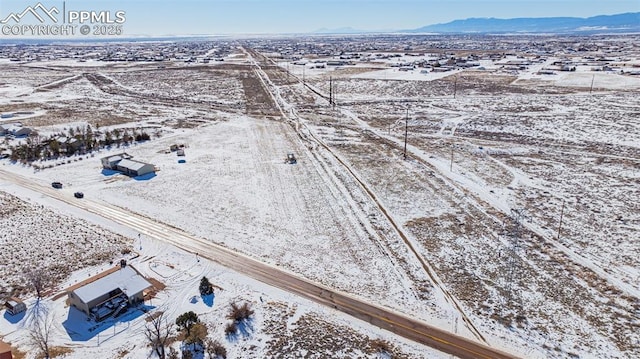 snowy aerial view featuring a mountain view