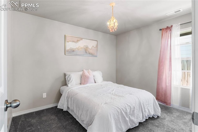 carpeted bedroom featuring an inviting chandelier