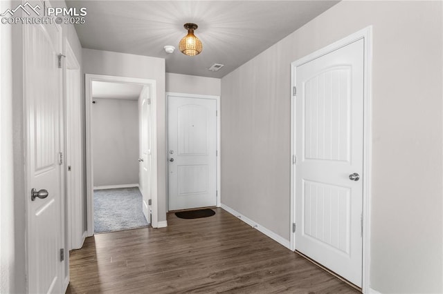 corridor with dark hardwood / wood-style flooring