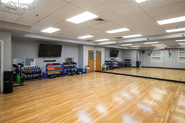 exercise room featuring a paneled ceiling and wood-type flooring