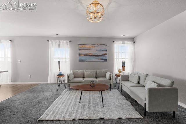 living room with dark hardwood / wood-style floors and a notable chandelier