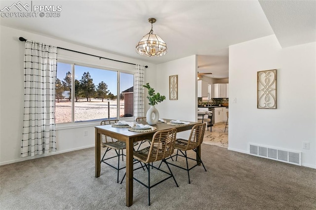 dining area with carpet floors and an inviting chandelier