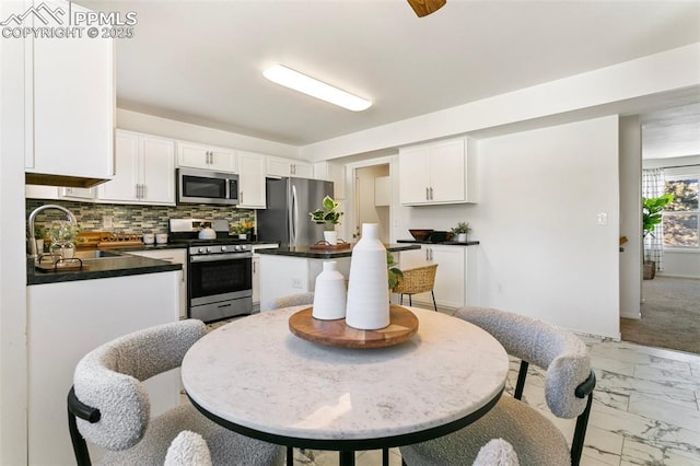 kitchen featuring white cabinetry, sink, tasteful backsplash, and stainless steel appliances