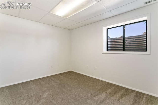 unfurnished room featuring a paneled ceiling and carpet flooring