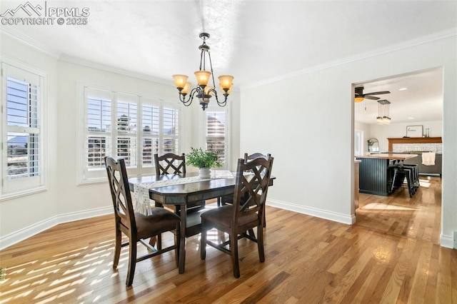 dining space featuring ornamental molding, wood-type flooring, and ceiling fan with notable chandelier