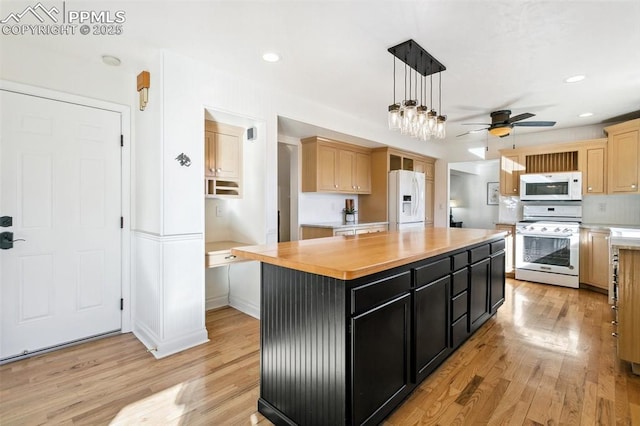 kitchen with a center island, light brown cabinetry, white appliances, and light wood-type flooring