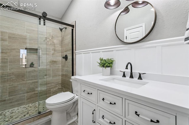 bathroom featuring vanity, toilet, and an enclosed shower