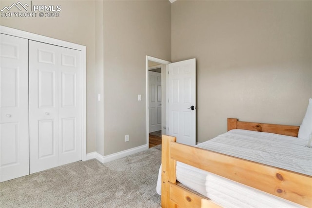 carpeted bedroom with a towering ceiling and a closet