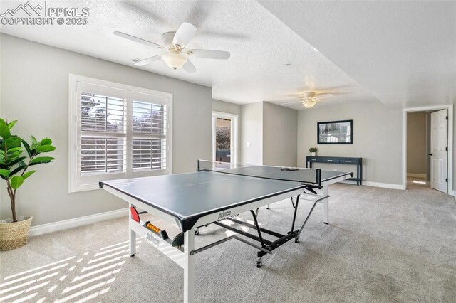 rec room with ceiling fan, light colored carpet, and a textured ceiling