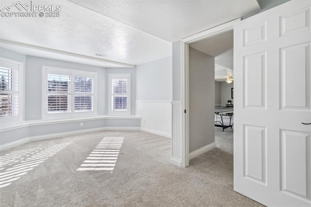 unfurnished room featuring light colored carpet and a textured ceiling