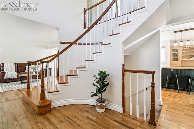 staircase featuring hardwood / wood-style flooring and a high ceiling