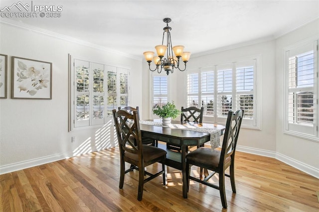 dining room with ornamental molding, a chandelier, and light hardwood / wood-style floors