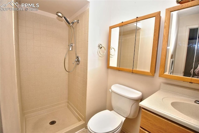 bathroom featuring vanity, toilet, and tiled shower