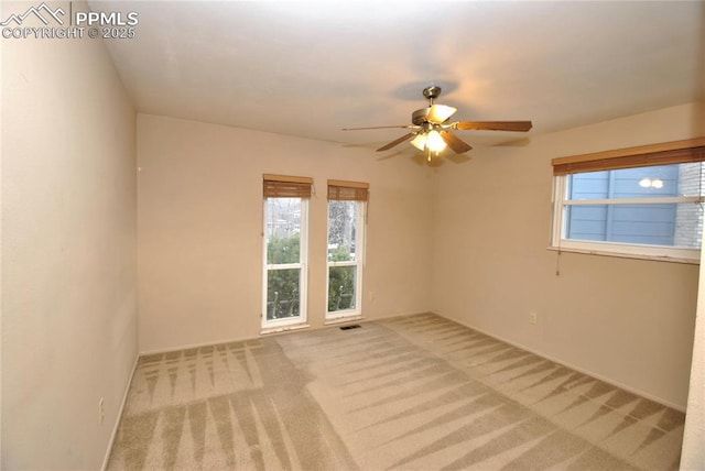 carpeted spare room with ceiling fan