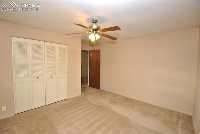 unfurnished bedroom with ceiling fan, light carpet, and a closet