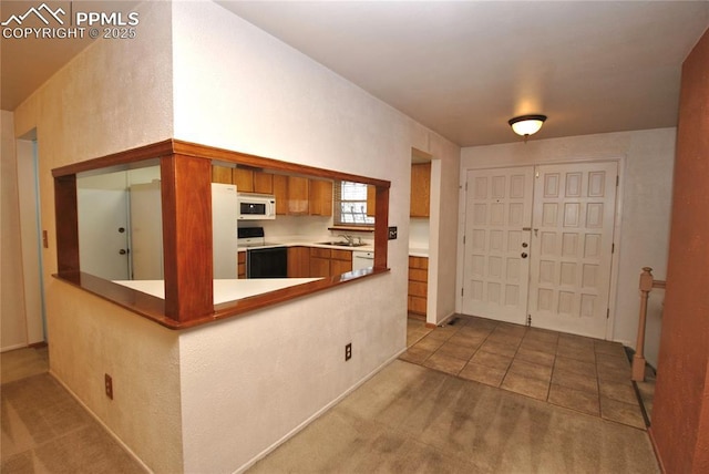 kitchen with light carpet, sink, white appliances, and kitchen peninsula