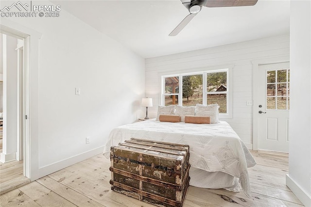 1636 Lakemoor Dr, Florissant, CO 80816 - bedroom featuring a ceiling fan, light wood-style flooring, wood walls, and baseboards