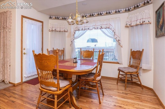 dining space featuring an inviting chandelier and hardwood / wood-style flooring