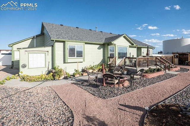 back of property featuring a wooden deck, a patio area, and a fire pit