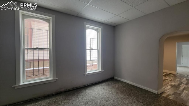 unfurnished room featuring carpet flooring and a drop ceiling