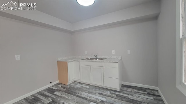 clothes washing area featuring sink and hardwood / wood-style floors