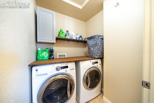 washroom with cabinets, washer and dryer, and light tile patterned flooring