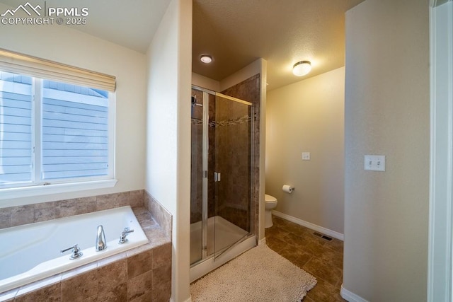 bathroom with plus walk in shower, a wealth of natural light, and toilet