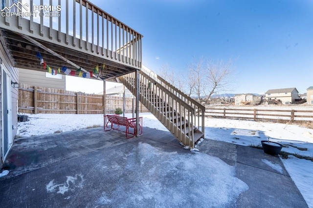 snow covered patio with a deck