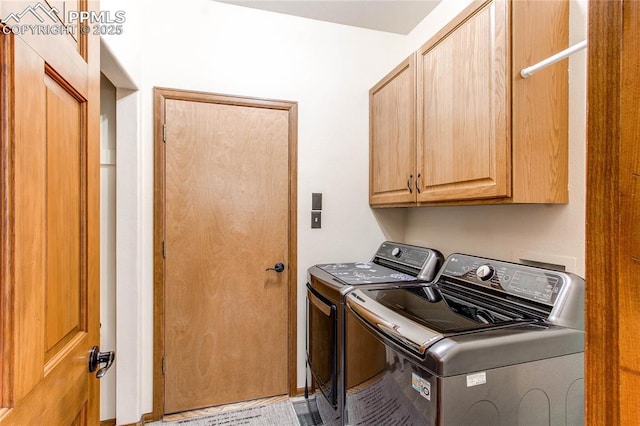 clothes washing area with independent washer and dryer and cabinets