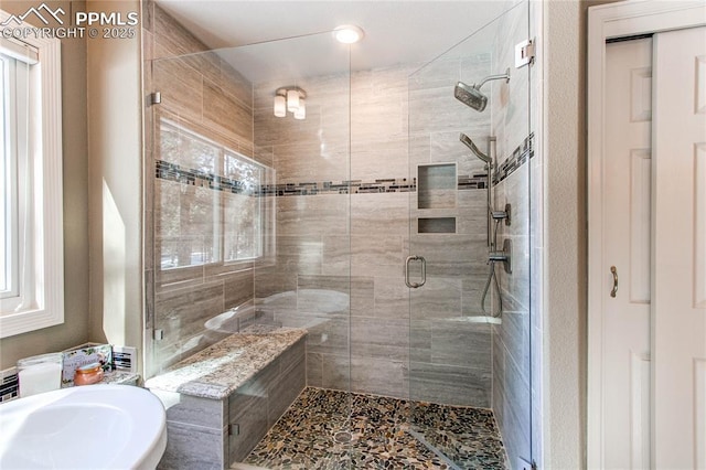 bathroom featuring plenty of natural light, sink, and walk in shower