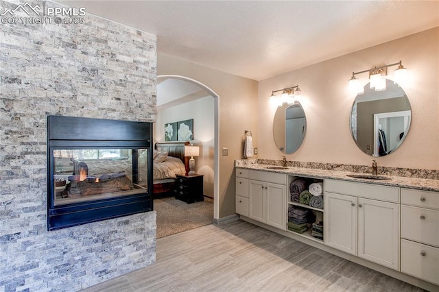 bathroom with hardwood / wood-style flooring, vanity, and a fireplace