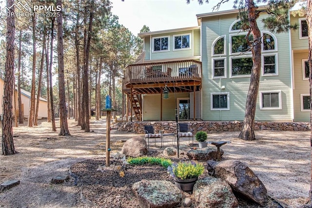 rear view of property featuring a wooden deck