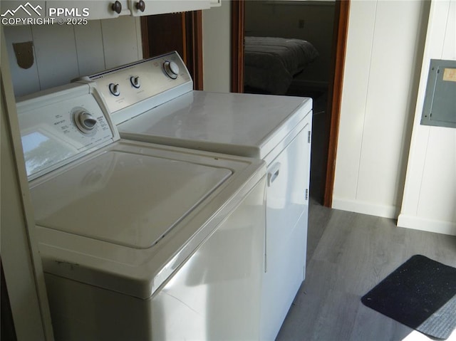 washroom with electric panel, laundry area, dark wood finished floors, and separate washer and dryer