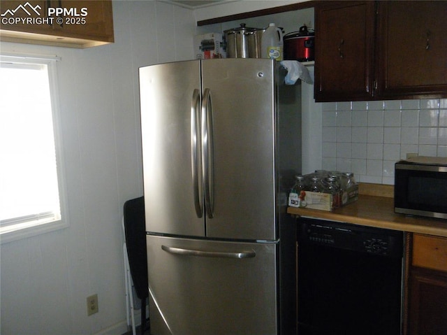 kitchen with decorative backsplash, dark brown cabinets, appliances with stainless steel finishes, and light countertops