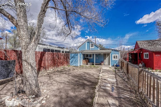 view of front facade with covered porch and fence private yard