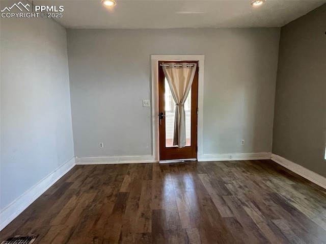 spare room with recessed lighting, visible vents, baseboards, and dark wood-type flooring