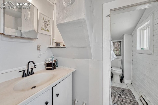 bathroom featuring a baseboard heating unit, tile patterned floors, toilet, and vanity