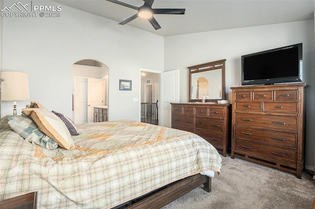 bedroom with ceiling fan, lofted ceiling, ensuite bathroom, and carpet