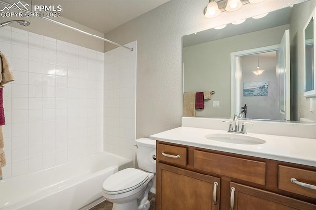 full bathroom featuring vanity, tiled shower / bath, and toilet