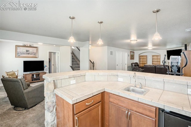 kitchen featuring pendant lighting, sink, and light carpet