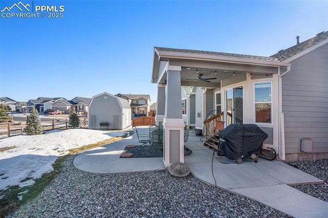 view of patio with ceiling fan, grilling area, and a shed