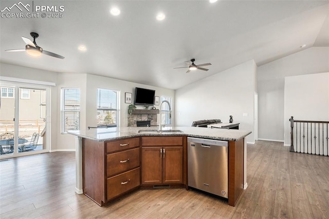 kitchen with lofted ceiling, sink, dishwasher, ceiling fan, and a kitchen island with sink