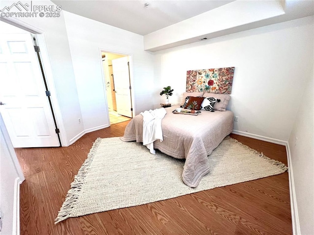 bedroom featuring wood-type flooring and ensuite bathroom